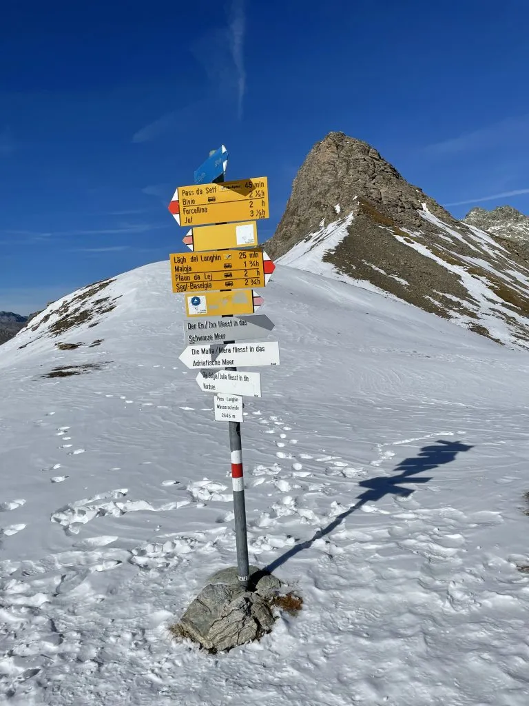 Wegweiser am verschneiten Lunghinpass