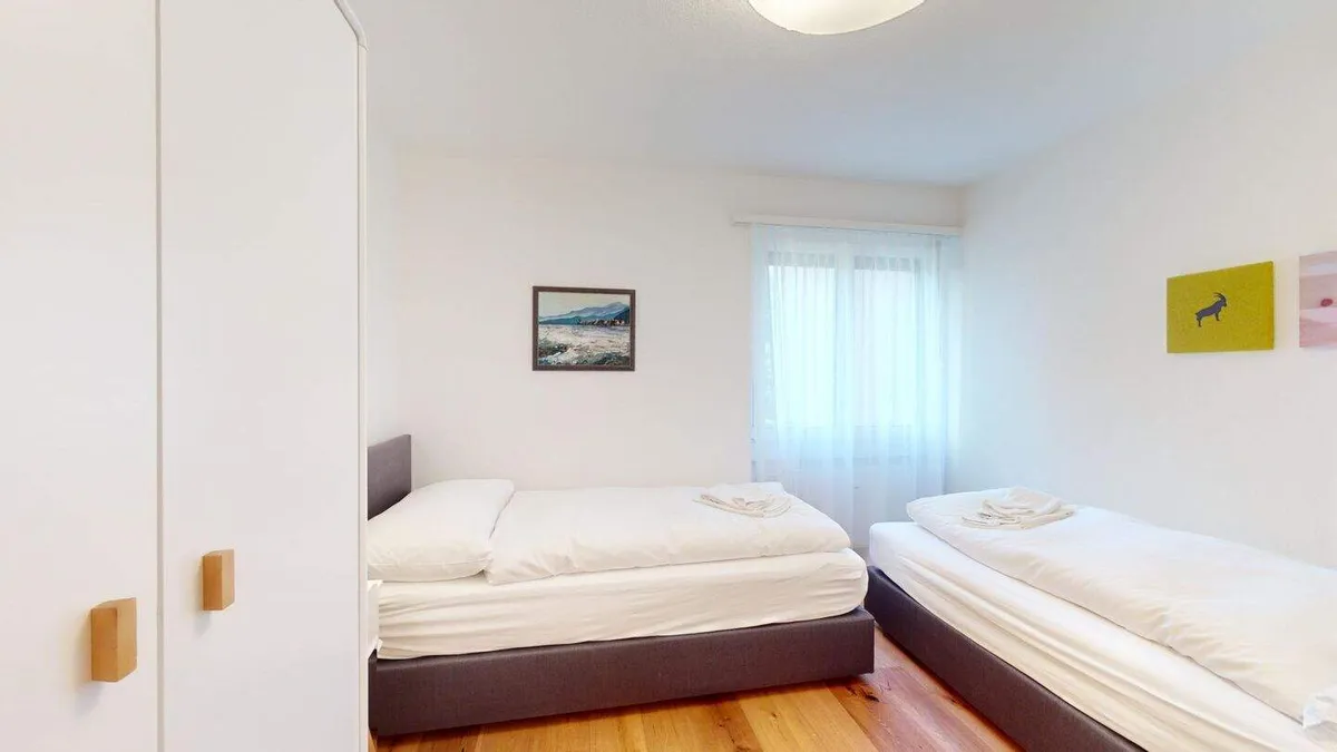 Zweites Schlafzimmer mit zwei Betten unter dem Fenster