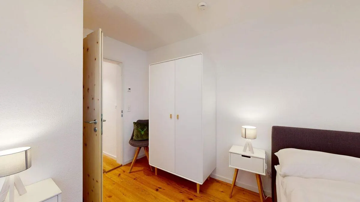 Zweites Schlafzimmer mit weissem Schrank und Bett