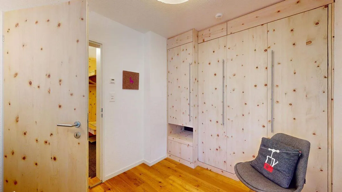 Bürozimmer mit Einbauschrank aus Arvenholz und Sessel