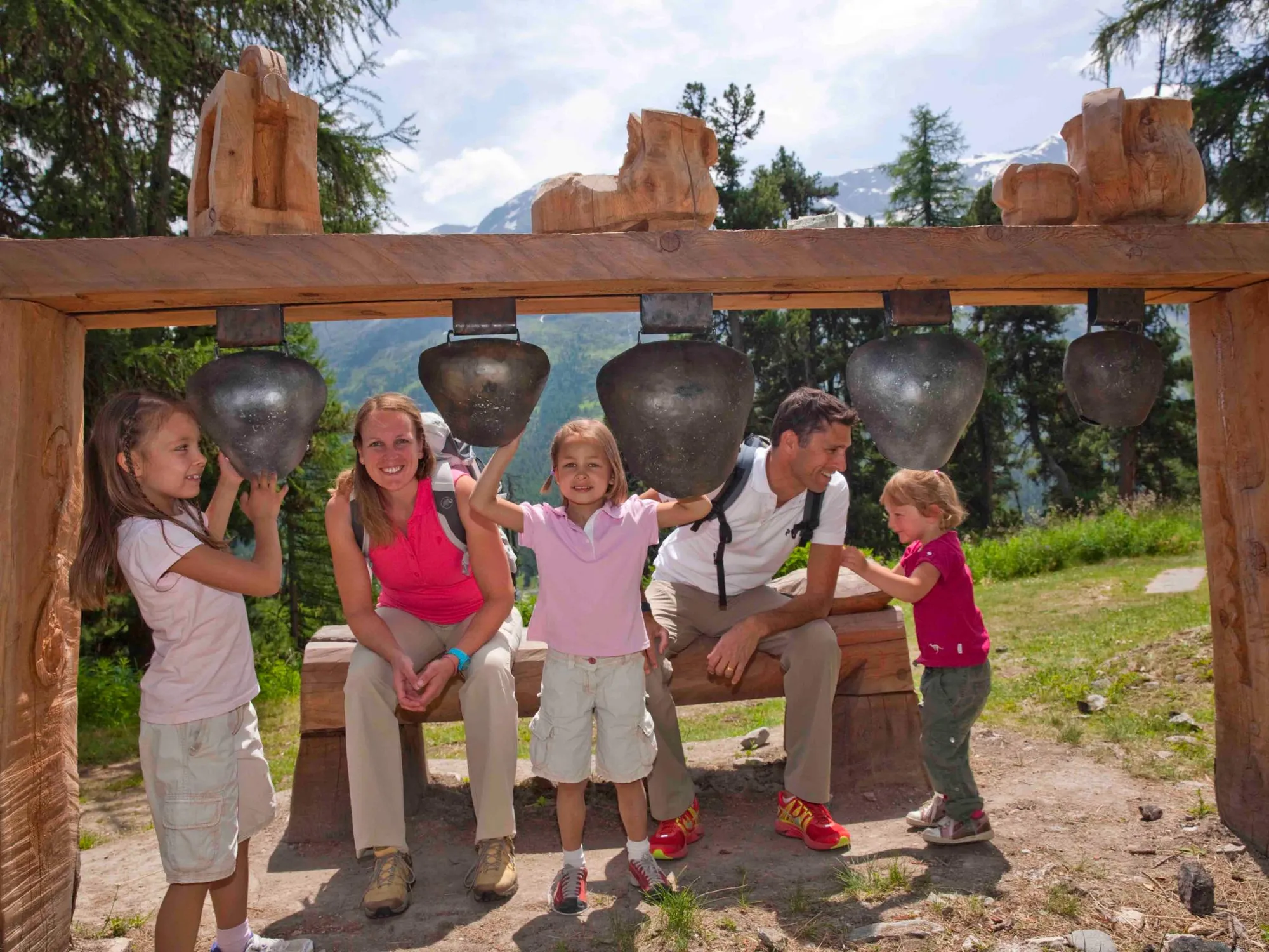 Family under large cowbells on the Schellenursli trail